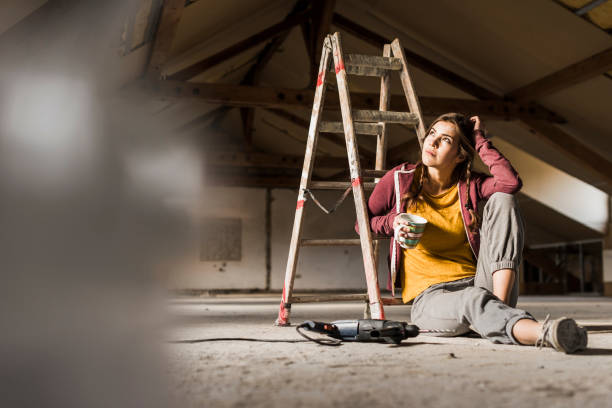 independent young woman renovating her new home, sittiing on floor with cup of coffee - home decoration fotografías e imágenes de stock