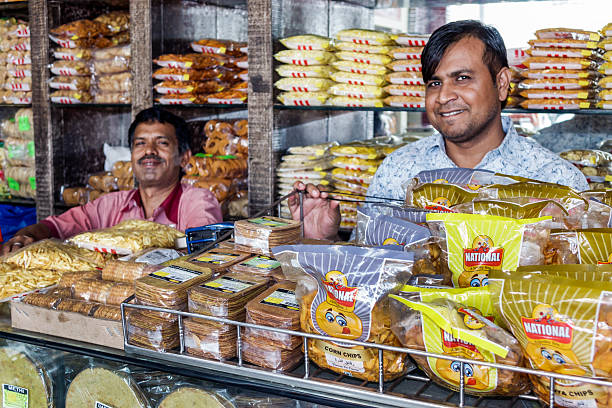 India Mumbai Apollo Bandar Colaba Causeway Market Shahid Bhagat Singh Marg snacks junk food sale display man coworkers.