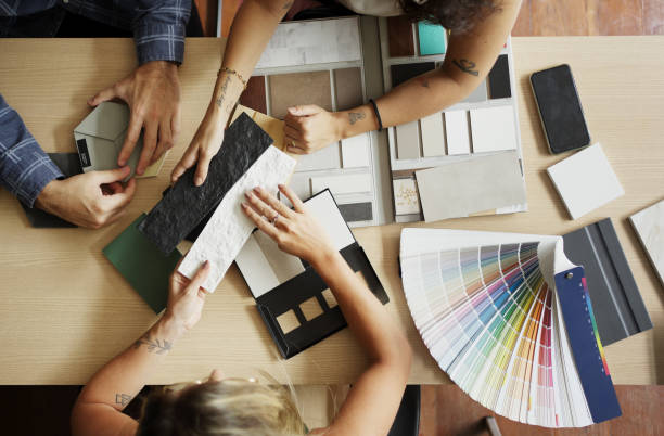 interior designer discussing tile and color options with clients in her office - home decoration stock pictures, royalty-free photos & images