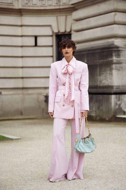 Irina Kro Eicke wears pink suit, wide pants and blazer with a belt and bow tie and mint green bag outside the Zimmermann fashion show during the...