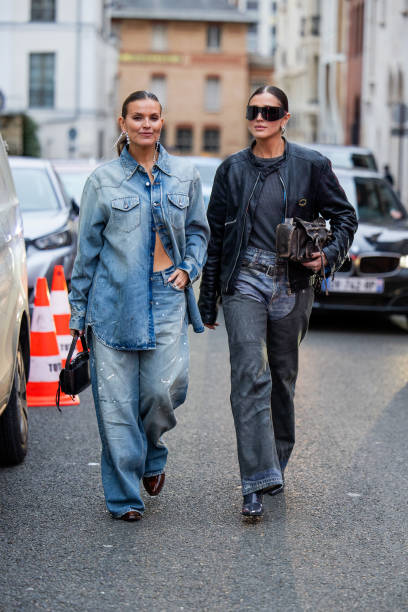 Janka Polliani wears denim shirt, jeans & Darja Barannik wears black jacket, jeans, brown bag outside Acne during the Womenswear Fall/Winter...