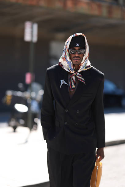 Jarred Vanderbilt is seen wearing a multicolored “Forever Scarf 90” in silk twill with horse prints from Hermès around his head, a black New Era cap...