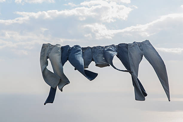 jeans hanging on a clothesline in the wind - fashion stock pictures, royalty-free photos & images