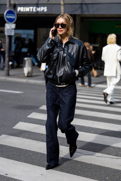 Jessie Andrews wears black leather jacket, navy pants, sunglasses outside Magda Butrym presentation during the Womenswear Fall/Winter 2025/2026 as...