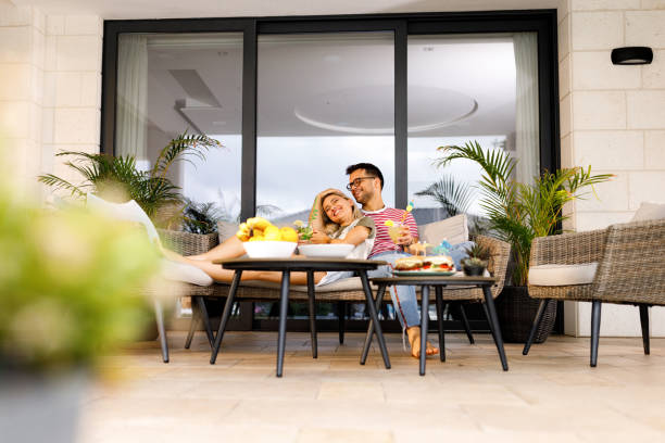 jeune couple heureux profitant ensemble sur un patio. - garden decoration photos et images de collection