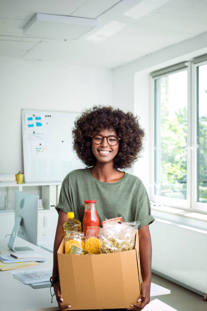 jeune femme tenant une boîte de dons - food photos et images de collection