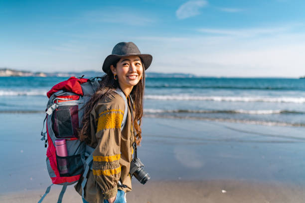 jeune voyageuse qui aime passer du temps à la plage pendant ses vacances - travel photos et images de collection