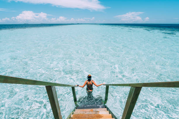 jonge volwassen vrouw verhuizen naar beneden naar de zee - travel stockfoto's en -beelden