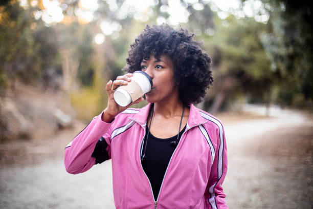 jonge zwarte vrouw lopen met koffie - coffee stockfoto's en -beelden