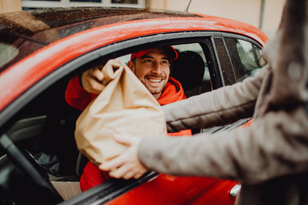 joyful delivery man delivering an order - food stock pictures, royalty-free photos & images