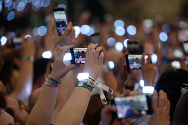 July 2024, North Rhine-Westphalia, Gelsenkirchen: Spectators film with their smartphones during singer Taylor Swift's concert in the Veltins Arena....