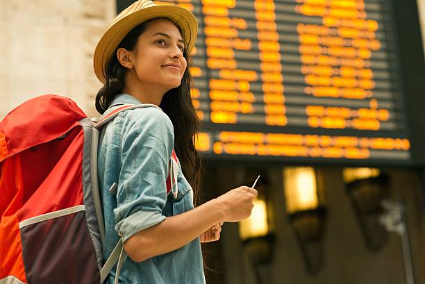 junge frau überprüft ihren zug in zeittafel - travel stock-fotos und bilder