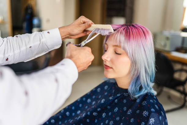 junge frau mit gefärbten haaren, die beim friseur einen haarschnitt bekommt - hairstyle stock-fotos und bilder