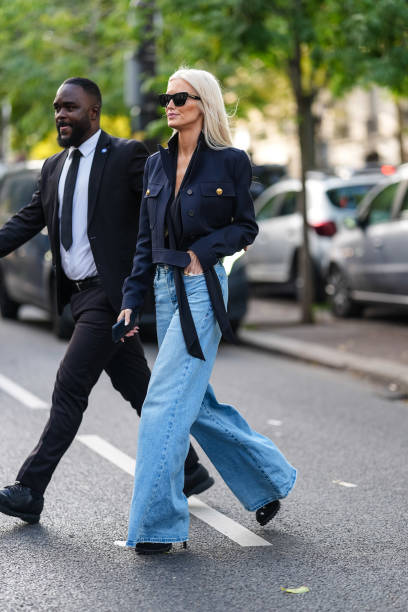Kate Davidson Hudson wears black sunglasses, dark navy blue cropped jacket, light blue high waisted denim jean pants, black platform leather heels,...