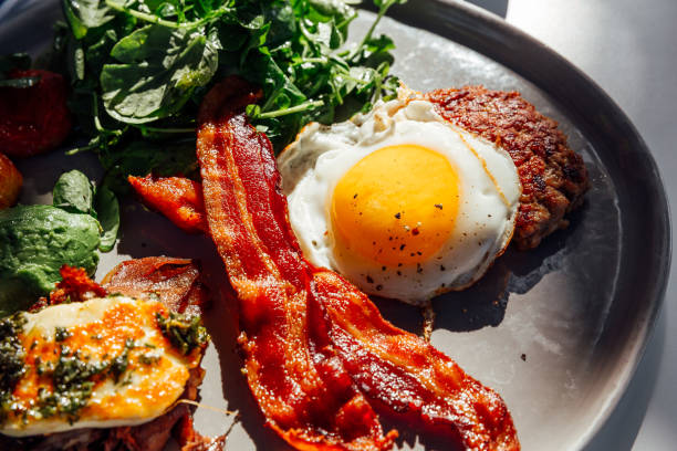 keto breakfast with fried egg, bacon, cheese, ground beef and salad - food stock pictures, royalty-free photos & images