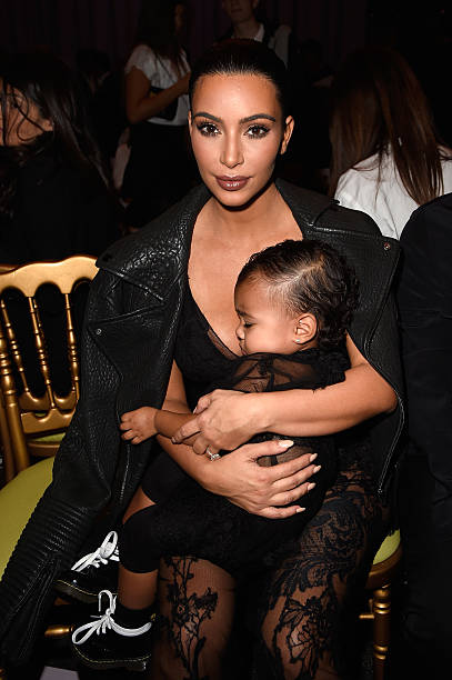 Kim Kardashian and baby North West attend the Givenchy show as part of the Paris Fashion Week Womenswear Spring/Summer 2015 on September 28, 2014 in...