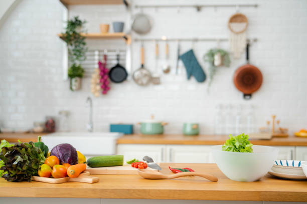 kitchen table with vegetables and cutting board for preparing salad . - food stock pictures, royalty-free photos & images