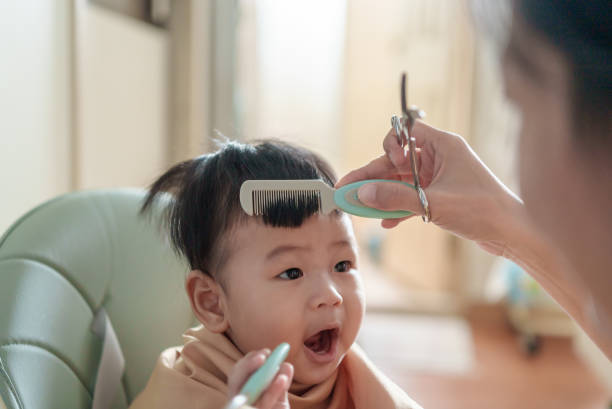 kleiner süßer asiatischer junge, der seinen ersten haarschnitt bekommt - hairstyle stock-fotos und bilder