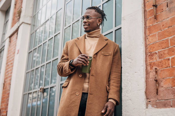 l’homme afro-américain moderne buvant le café à emporter le café à l’extérieur dans la ville - fashion photos et images de collection