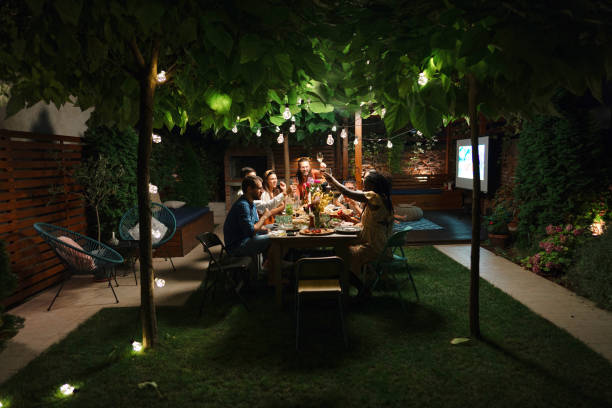 la famille et quelques amis profitent d’un repas en plein air dans une cour ensemble. - garden decoration photos et images de collection