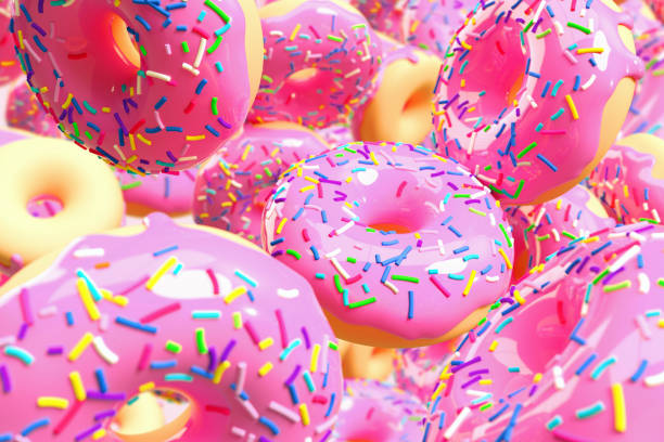 large number of pink frosted doughnuts falling. - junk food stock pictures, royalty-free photos & images