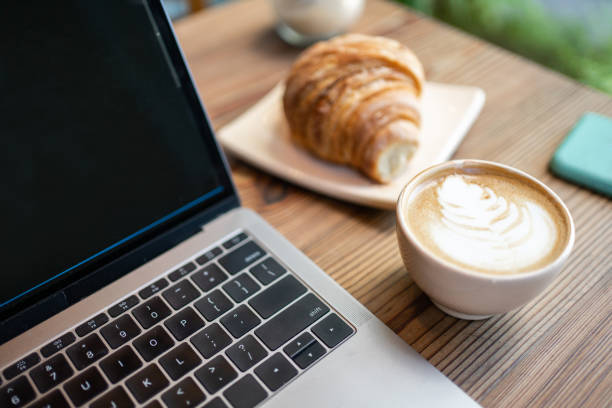 latte kunstkoffie met laptopcomputer en croissant op koffielijst - coffee stockfoto's en -beelden
