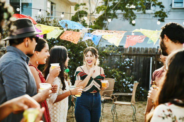 laughing group of friends sharing drinks during backyard barbecue on summer afternoon - garden decoration stock pictures, royalty-free photos & images