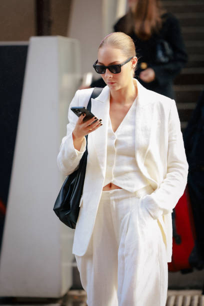 Lauren Burns wearing black sunglasses and white suit during the Australian Fashion Week Presented By Pandora 2024 at Carriageworks on May 13, 2024 in...
