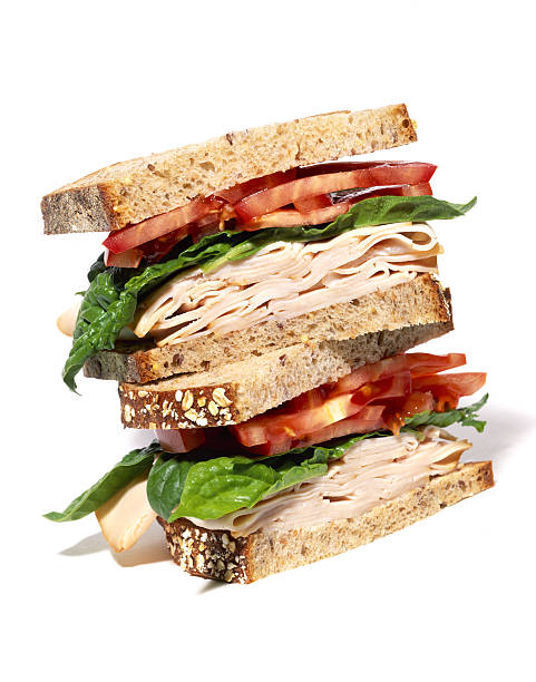 layered turkey sandwich with lettuce and tomato - food stock pictures, royalty-free photos & images