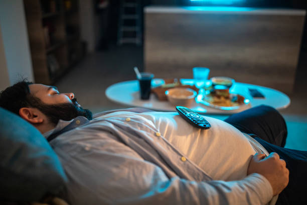 lazy man fell asleep in living room - junk food stock pictures, royalty-free photos & images
