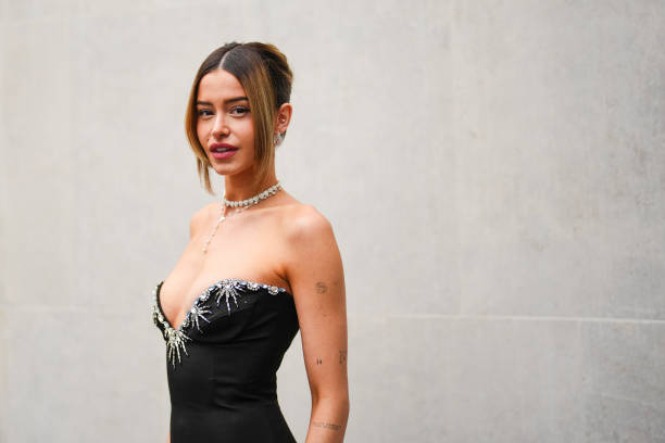 Lea Elui wears white gold diamond earrings, white gold diamond choker necklace, pearl gold necklace, white gold diamond bracelet, black corset...