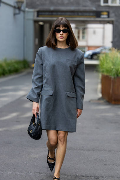 Lea Naumann wears grey oversized dress, black Miu Miu bag outside Gestuz during day four of the Copenhagen Fashion Week SS25 on August 08, 2024 in...