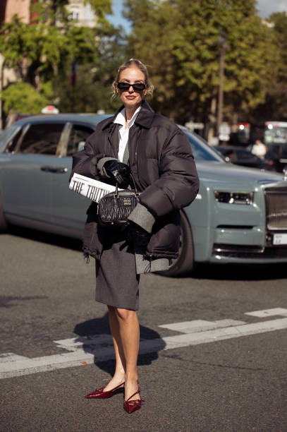 Leonie Hanne wears dark geri skirt, white shirt oversized jacket and black bag outside the Miu Miu show during Womenswear Spring/Summer 2025 as part...