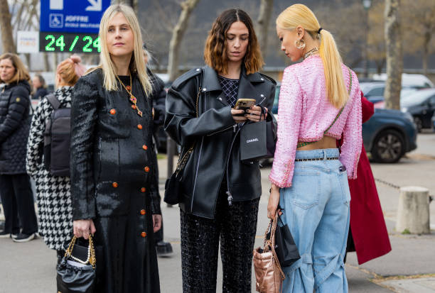 Linda Tol wears sequined black button up dress & Erika Boldrin wears black pants, leather jacket & Niki Wu Jie wears pink jacket, denim jeans outside...