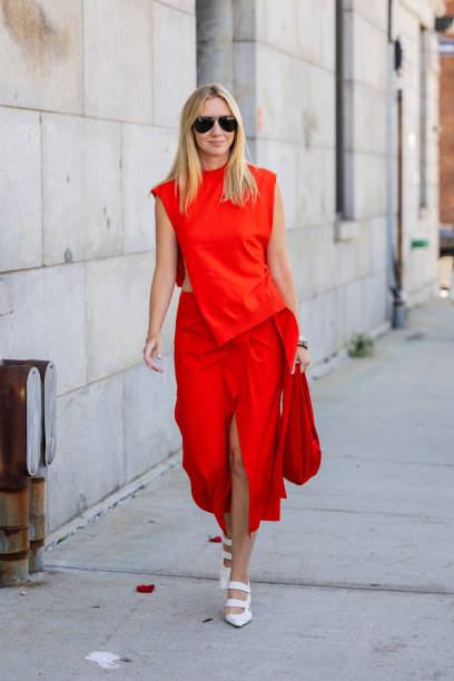 Lisa Aiken wears red sleeveless top, skirt with slit, bag outside Gabriela Hearst on September 12, 2023 in New York City.