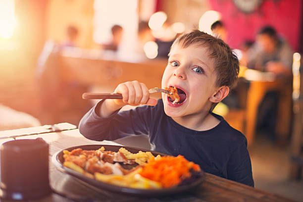 little boy enjoying dinner at the restaurant - food stock pictures, royalty-free photos & images