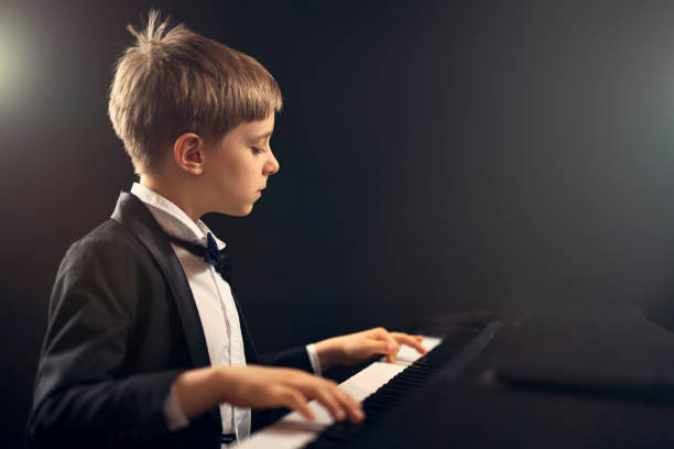 little boy virtuoso performing piano concerto - concert stock pictures, royalty-free photos & images