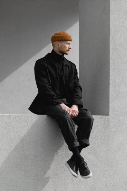 lonely stylish young man on the windowsill - fashion stock pictures, royalty-free photos & images