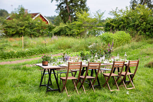 long outdoor dining table in lush swedish garden - garden decoration stock pictures, royalty-free photos & images