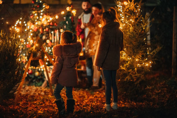 lovely family enjoying their decorated yard at christmas eve - garden decoration stock pictures, royalty-free photos & images