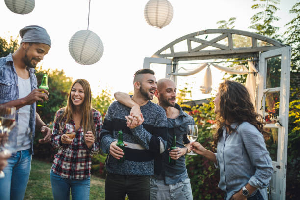 lovely married homosexual couple hosting a party - garden decoration stock pictures, royalty-free photos & images