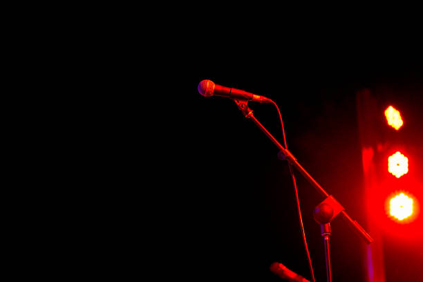 low angle view of a microphone on stage at a live concert with dark background - concert photos et images de collection