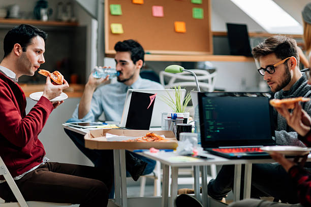 lunch time in the office. - junk food stockfoto's en -beelden