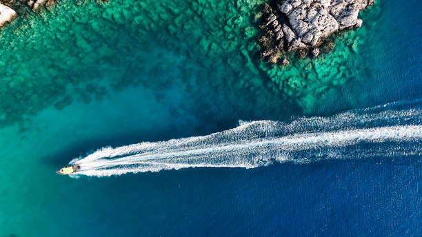 luxury speed boat floating in open sea at summer, yacht sailing in sea at hot summer day, seashore of mediterranean sea at summer, cruise speed boat floating in sea along rocky mountain coastline of mediterranean sea - travel