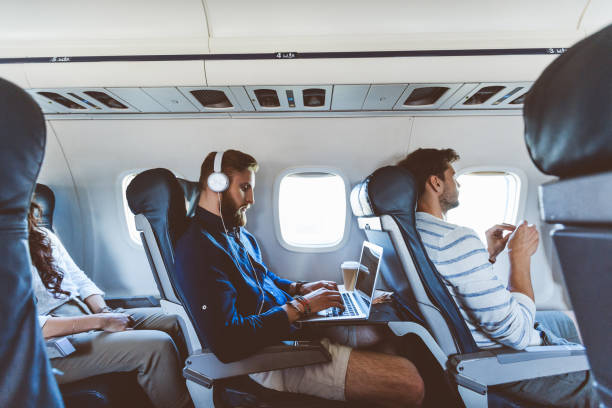 männlichen passagier mit laptop während des fluges - travel stock-fotos und bilder