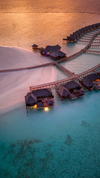 maldives island resort in sunset with view over horizon drone view - travel stock pictures, royalty-free photos & images