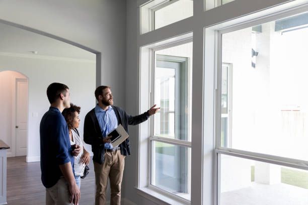 male real estate agent shows a couple a beautiful home - home decoration stock pictures, royalty-free photos & images