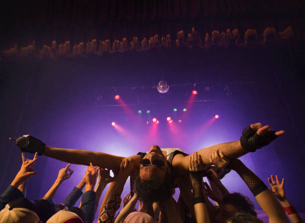 male rock star crowd surfing - concert stock pictures, royalty-free photos & images