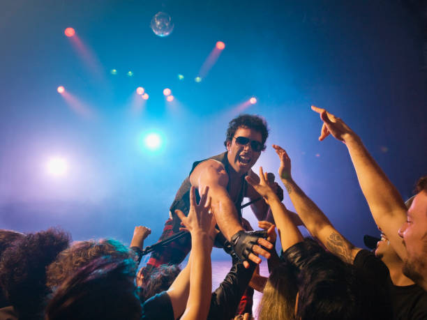 male rock star on stage interacting with audience - concert stock pictures, royalty-free photos & images