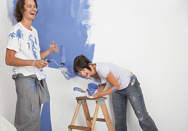 man and woman playing with paint - home decoration stock pictures, royalty-free photos & images